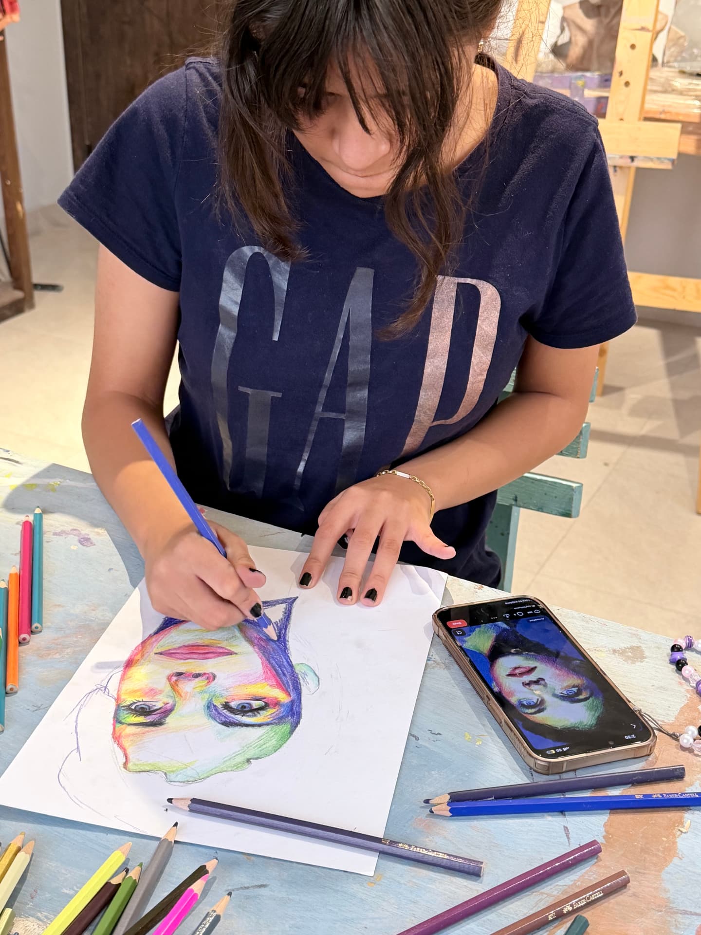 Student drawing a colorful portrait with colored pencils